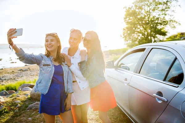 Mujeres felices tomando selfie cerca de coche en la playa — Foto de Stock