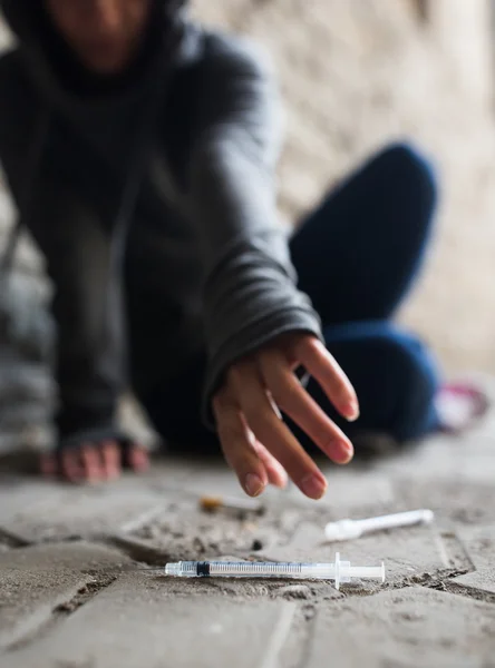 Close up of addict woman reaching to drug syringes — Stock Photo, Image