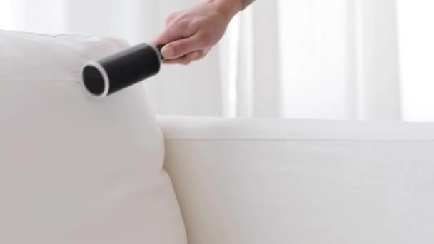 Vrouw met kleverige roller sofa bekleding reinigen — Stockvideo