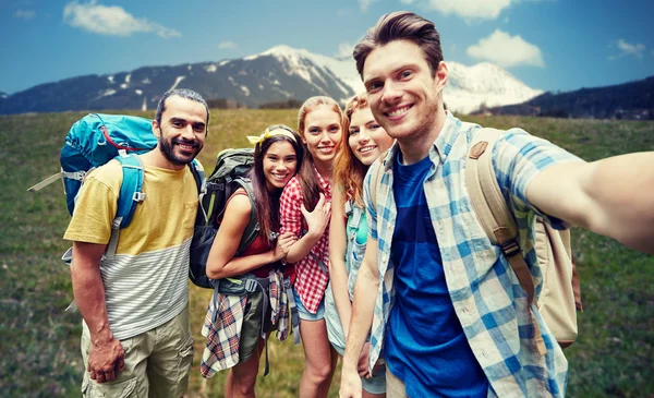 Przyjaciele z plecaka biorąc selfie w drewnie — Zdjęcie stockowe