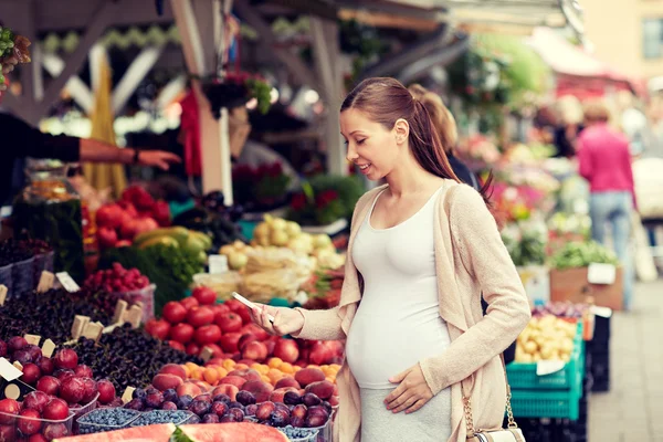 Kobieta w ciąży z smartphone przy ulicy rynek — Zdjęcie stockowe