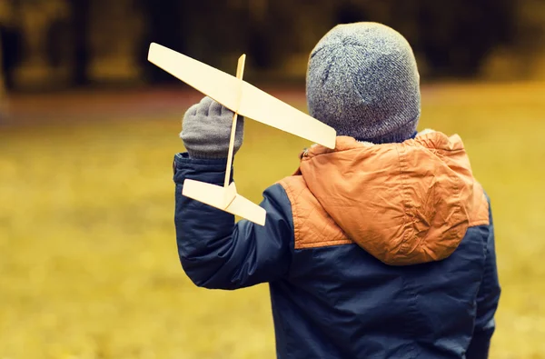 Happy little boy playing with toy plane outdoors — Stock Photo, Image