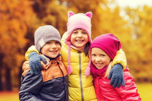 Gruppe fröhlicher Kinder umarmt sich im Herbstpark — Stockfoto