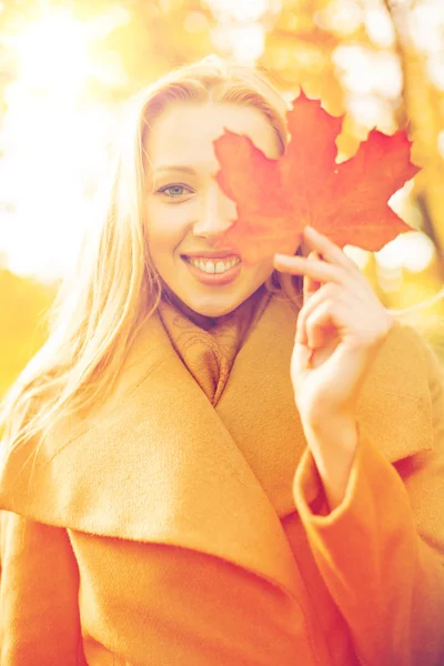 Frau mit rotem Marmorblatt im Herbstpark — Stockfoto