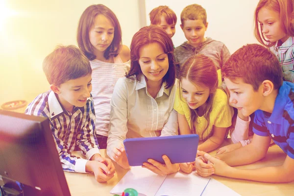 Grupo de niños con profesor y tablet PC en la escuela — Foto de Stock