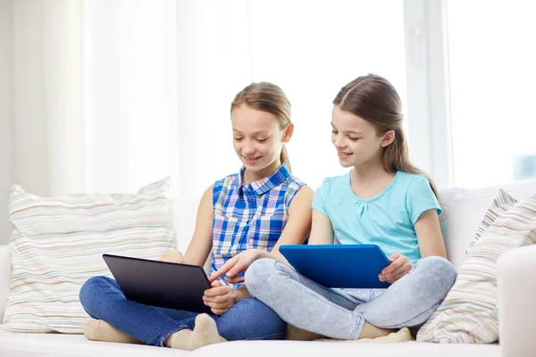 Meninas felizes com tablet pc sentado no sofá em casa — Fotografia de Stock