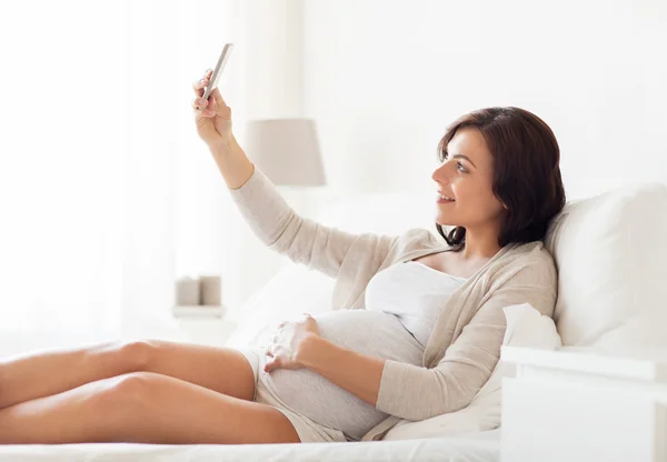 Femme enceinte prenant smartphone selfie à la maison — Photo