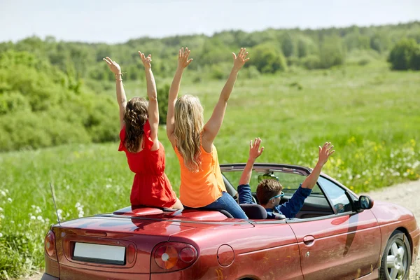 Amigos felices conduciendo en coche cabriolet en el país — Foto de Stock