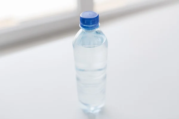 Nahaufnahme einer Flasche mit Trinkwasser auf dem Tisch — Stockfoto