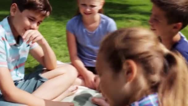 Group of happy kids sitting on grass and talking — Stock Video