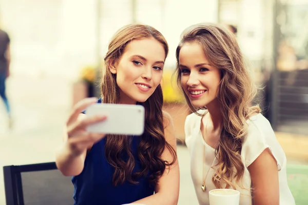 Mujeres felices con teléfono inteligente tomando selfie en la cafetería — Foto de Stock