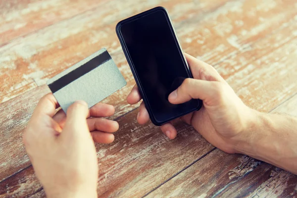 Primo piano delle mani con smart phone e carta di credito — Foto Stock