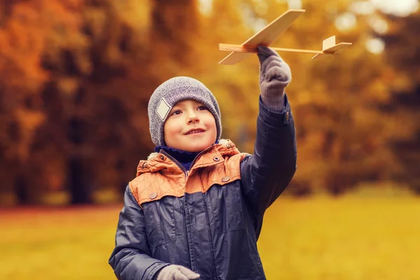 Menino feliz brincando com avião de brinquedo ao ar livre — Fotografia de Stock