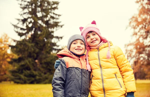 Fröhliche kleine Mädchen und Jungen im Herbstpark — Stockfoto