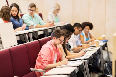 group of students with notebooks in lecture hall clipart