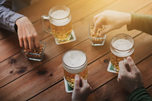 Close up of hands with beer mugs at bar or pub — Stock Photo, Image