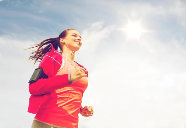 Smiling young woman running outdoors — Stock Photo, Image