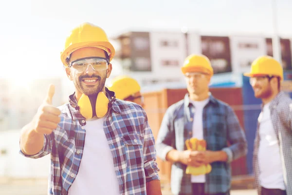 Grupo de constructores sonrientes en hardhats al aire libre —  Fotos de Stock