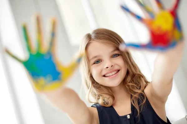 Happy girl showing painted hand palms at home — Stock Photo, Image