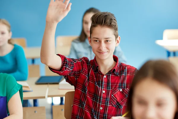 Student szczęśliwy chłopiec podnoszenie ręki w szkole lekcji — Zdjęcie stockowe