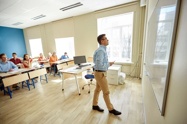 Students and teacher writing on school white board — Stock Photo, Image