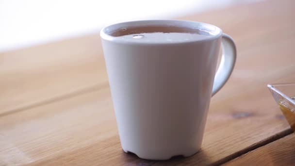 Sucre en morceaux tombant dans une tasse de thé et éclaboussures — Video