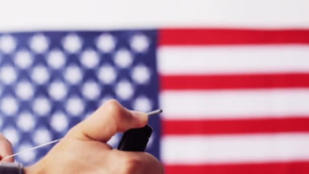 Close-up van de hand met sparkler over Amerikaanse vlag — Stockvideo