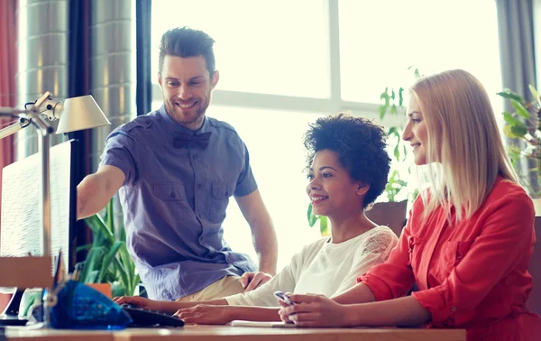 Équipe créative heureuse avec ordinateur au bureau — Photo