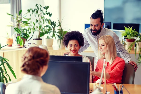 Lykkelig kreativ gruppe med datamaskin i embetet – stockfoto