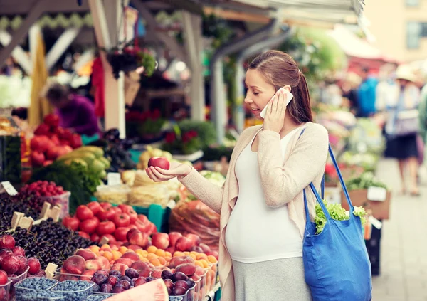 Mulher grávida chamando no smartphone no mercado — Fotografia de Stock