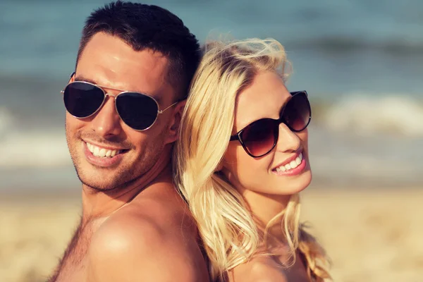 Feliz pareja en traje de baño sentado en la playa de verano —  Fotos de Stock