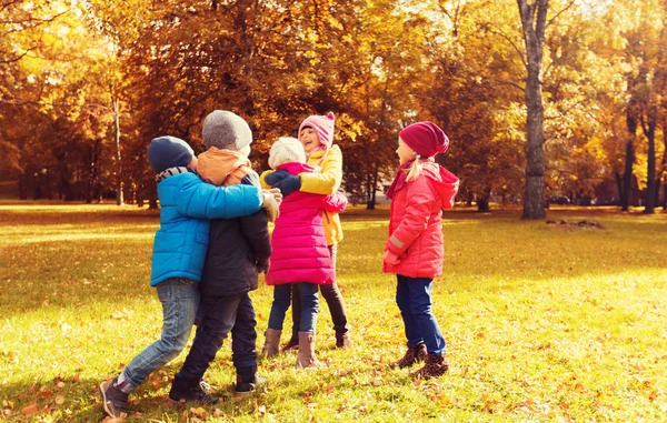 Gruppe fröhlicher Kinder umarmt sich im Herbstpark — Stockfoto