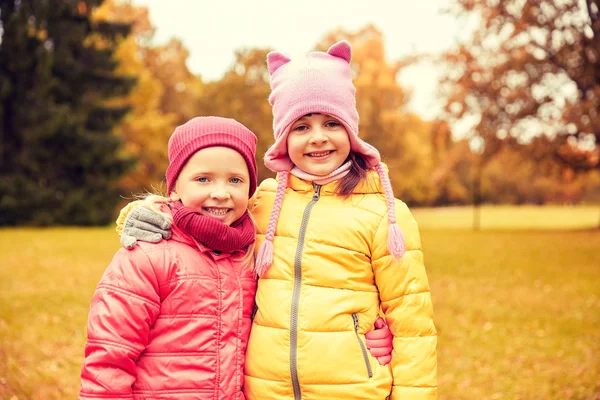 Dvě šťastné děvčátka objímala v podzimním parku — Stock fotografie
