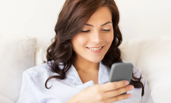 Mulher feliz com smartphone em casa — Fotografia de Stock