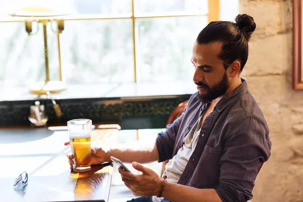 Mann mit Smartphone trinkt Bier in Bar oder Kneipe — Stockfoto