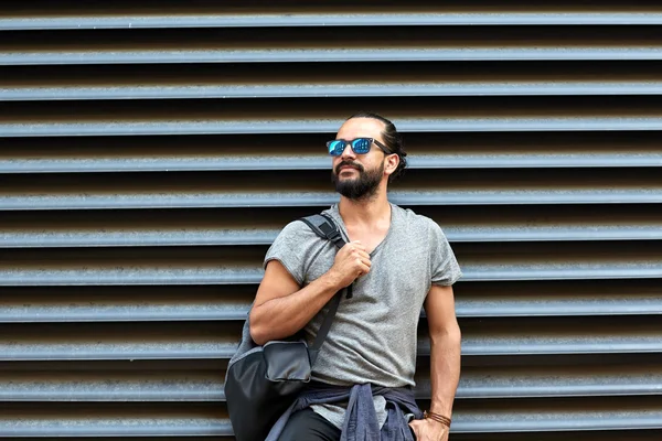 Uomo con zaino in piedi al muro della strada della città — Foto Stock