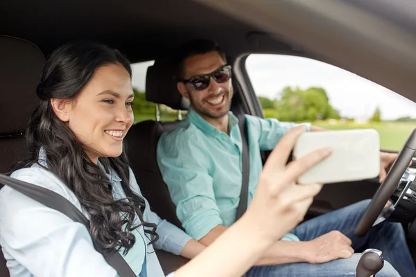 Szczęśliwa para w samochód biorąc selfie z smartphone — Zdjęcie stockowe