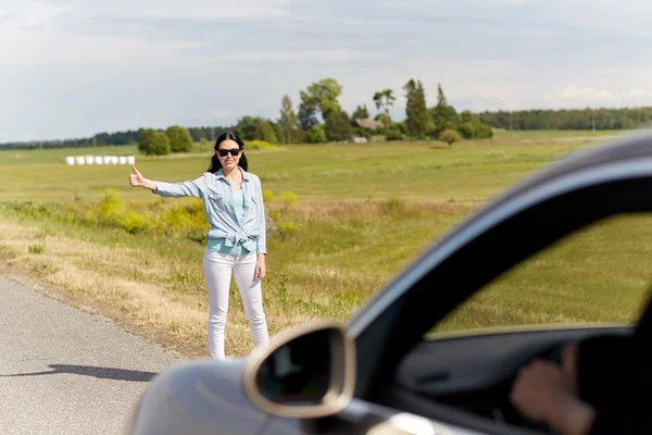 Mulher carona e parar de carro no campo — Fotografia de Stock