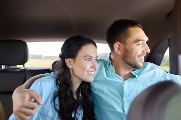 Счастливые мужчина и женщина обнимаются в машине — стоковое фото
