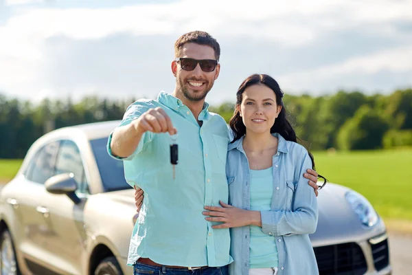 Šťastný muž a žena s auto klíčové objímání — Stock fotografie