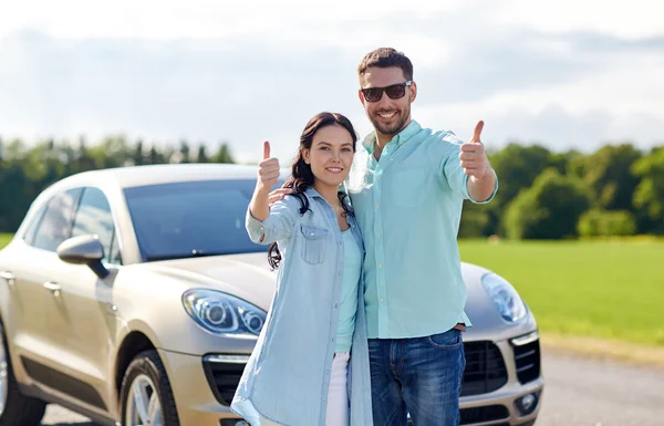 Glücklicher Mann und Frau zeigt Daumen hoch am Auto — Stockfoto