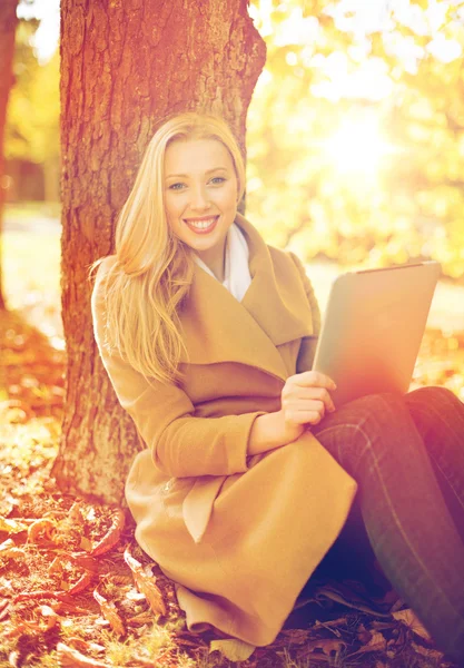 Tablet pc 在秋天的公园里的女人 — 图库照片