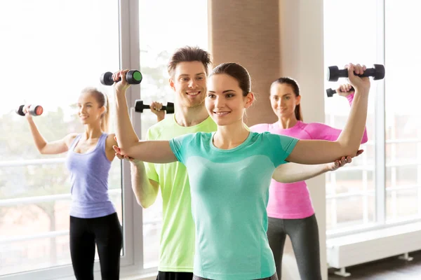 Group of smiling people exercising with dumbbells — Stock Photo, Image