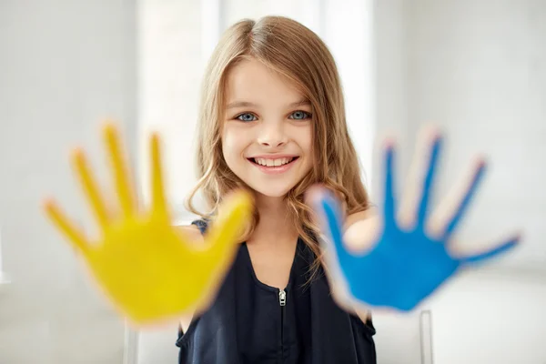 Ευτυχισμένος κορίτσι δείχνει ζωγραφισμένα χέρι παλάμες στο σπίτι — Φωτογραφία Αρχείου