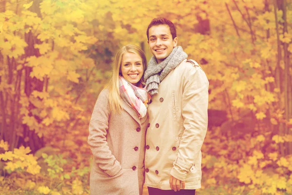 Усміхнена пара обіймається в осінньому парку — стокове фото