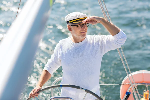 Senior pria di helm di perahu atau kapal pesiar berlayar di laut — Stok Foto