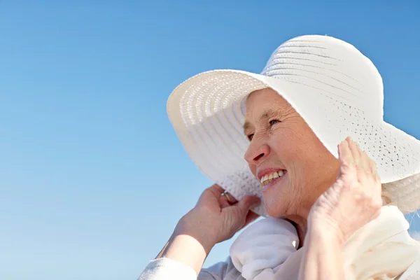 Mulher sênior feliz em chapéu de sol na praia de verão — Fotografia de Stock