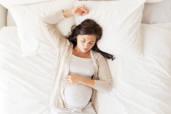 Glad gravid kvinna sover i sängen hemma — Stockfoto