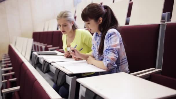 Студентки с блокнотами в лекционном зале — стоковое видео