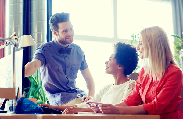 Équipe créative heureuse avec ordinateur au bureau — Photo